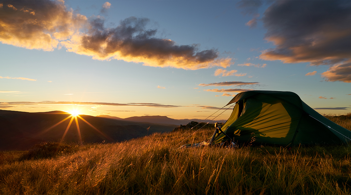 Tent op een heuvel in Engeland, met de zon laag op de horizon